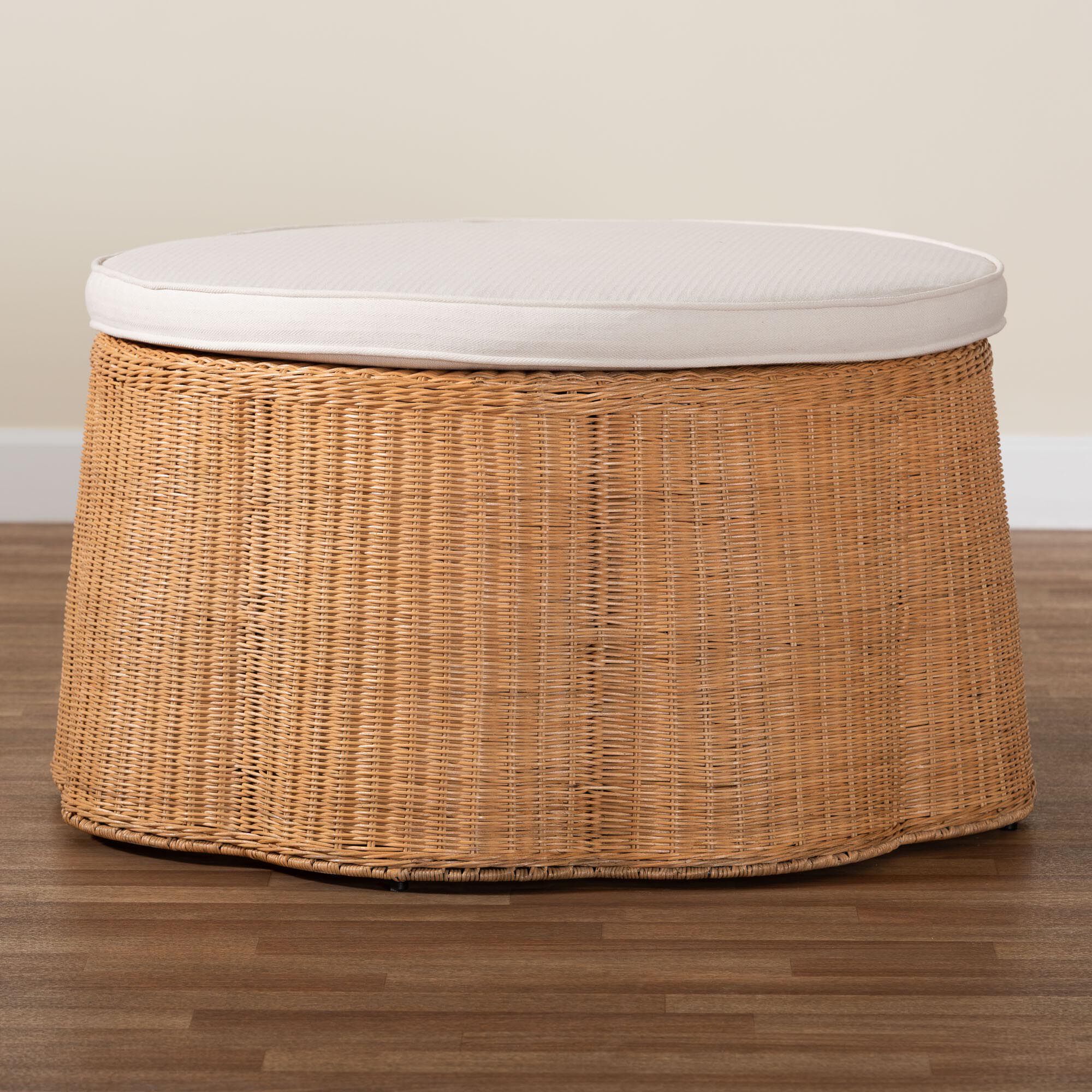 Round natural rattan ottoman with white cushion on wooden floor