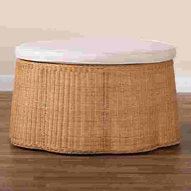 Round natural rattan ottoman with white cushion on wooden floor