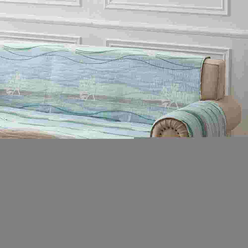 Side view of beige sofa showing quilted blue protector
