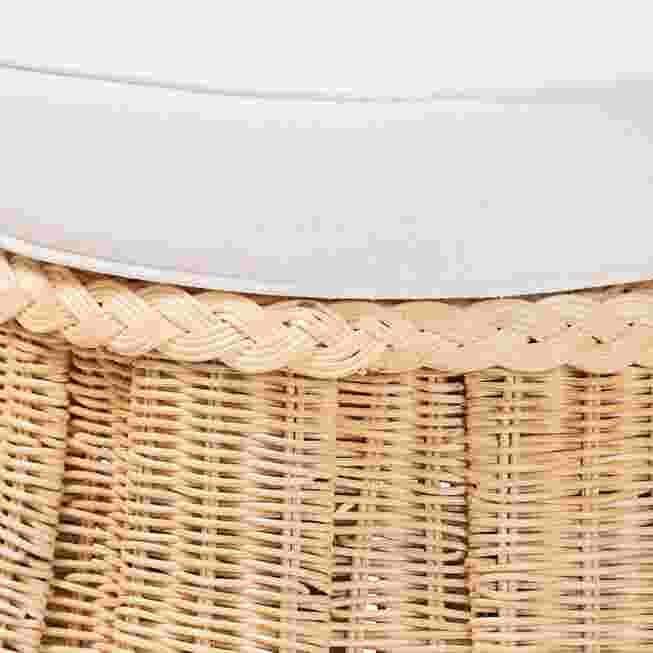Close-up of the top edge of the rattan ottoman with white cushion
