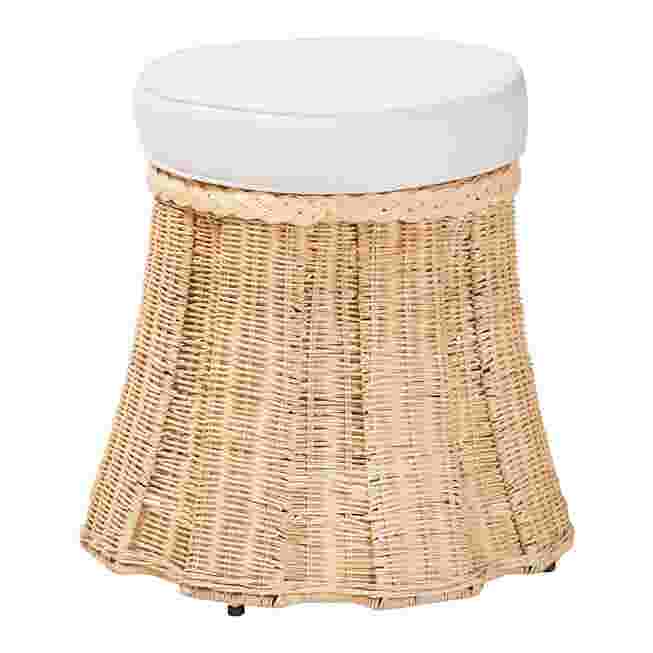Round natural rattan ottoman with white cushion on a white background