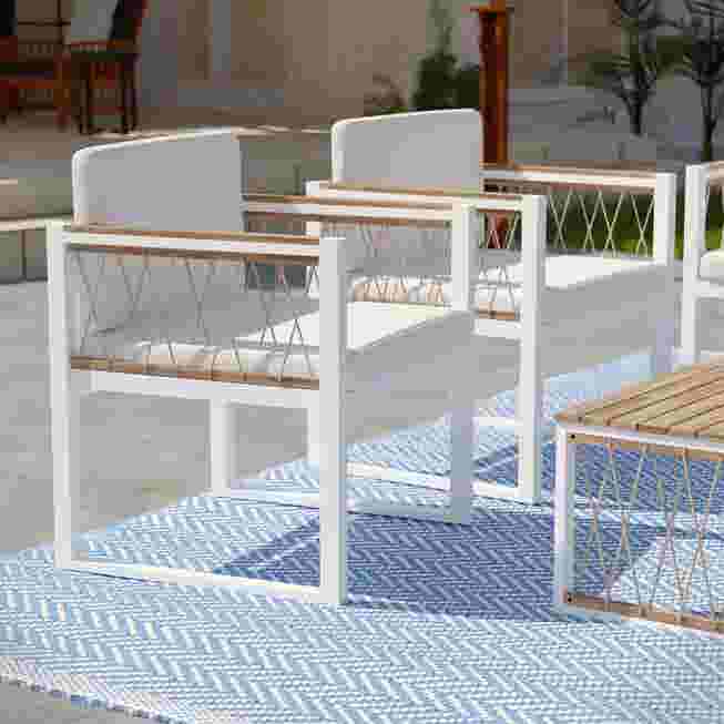 Two white outdoor chairs on a patio