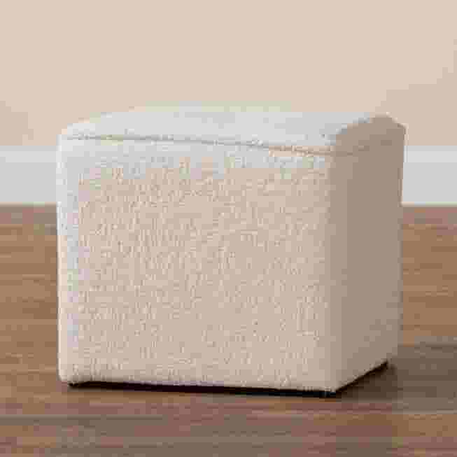 Ivory boucle upholstered ottoman on a wooden floor