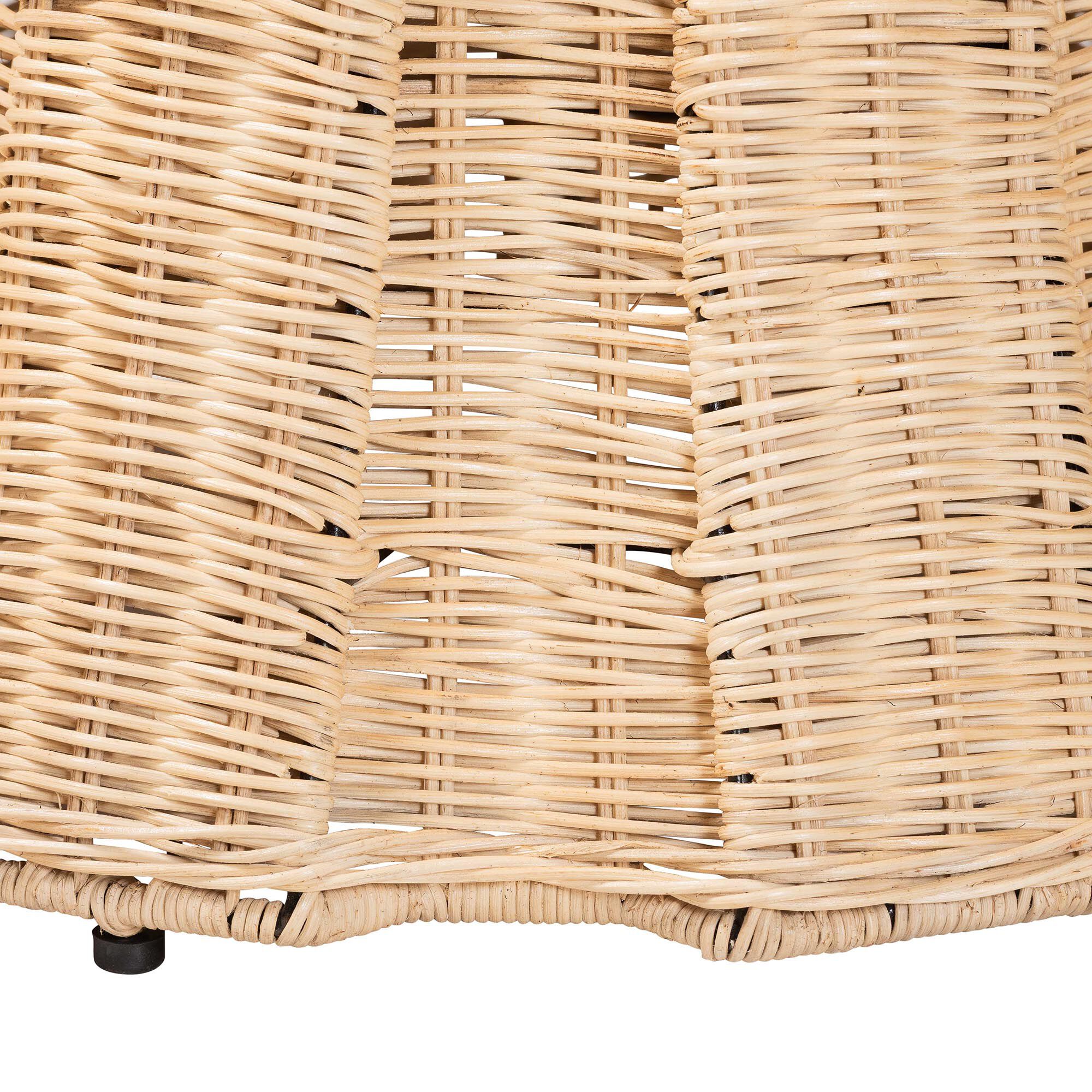 Close-up of the woven rattan base and small black feet of the ottoman